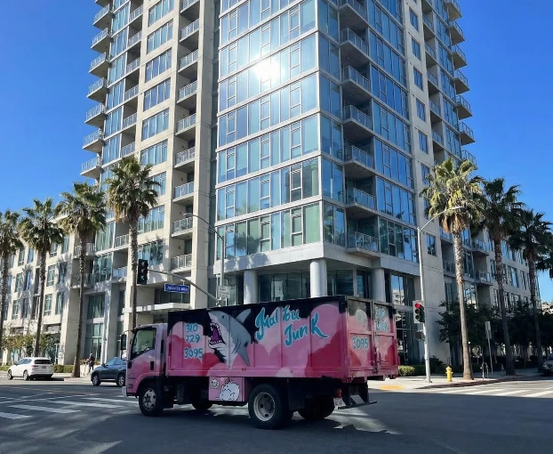 The junk removal truck in front of a high rise apartment in los angeles