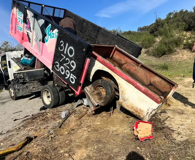 The junk removal truck loading an old trailer near san fernando valley