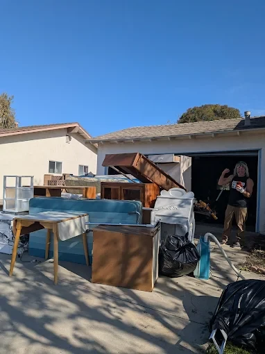 The owner of Malibu Junk Removal, Pepper foster cleaning out a garage